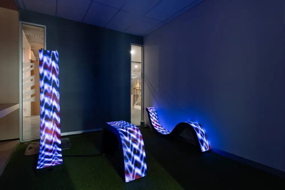 Blue-patterned LED forms installed across a gallery floor