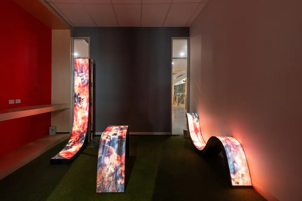 LED vines displaying organic scans along a red gallery wall