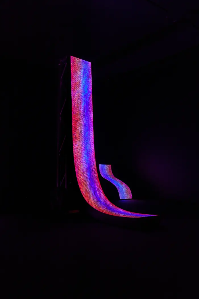 Tall vertical LED screen rising from the floor in darkness